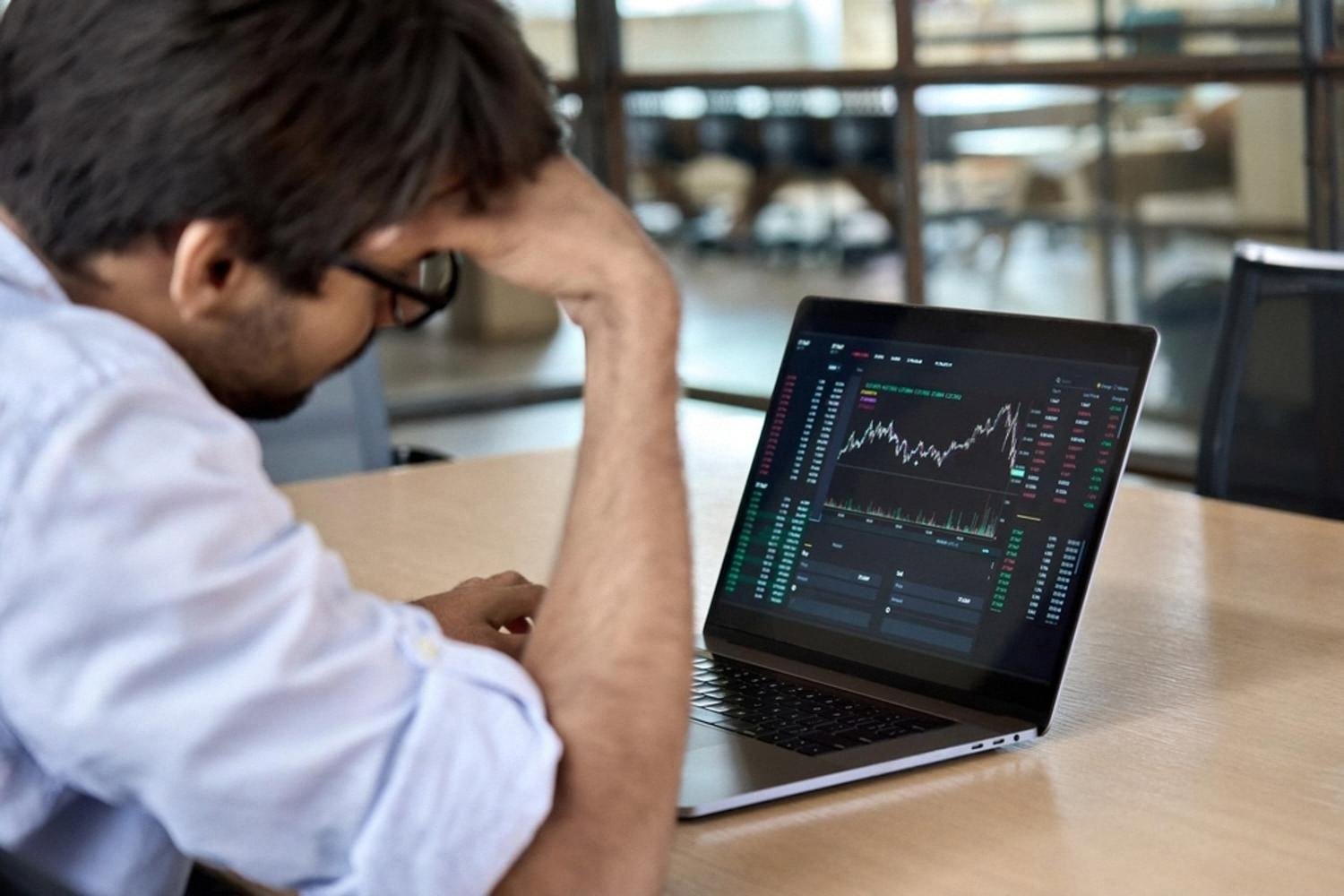 Investor reviewing stock market charts on a laptop, considering long-term investing options in the UAE